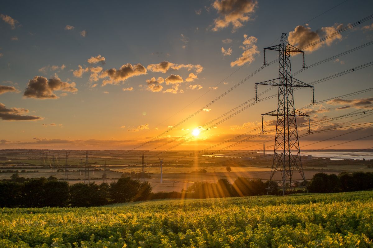 An image of powerlines against a sunset in a rural location illustrating electricity supply in the uk,