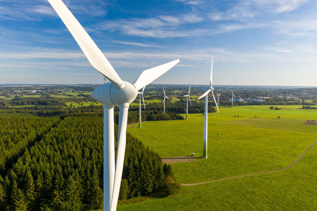 renewable energy for businesses - a wind turbine set against green hills