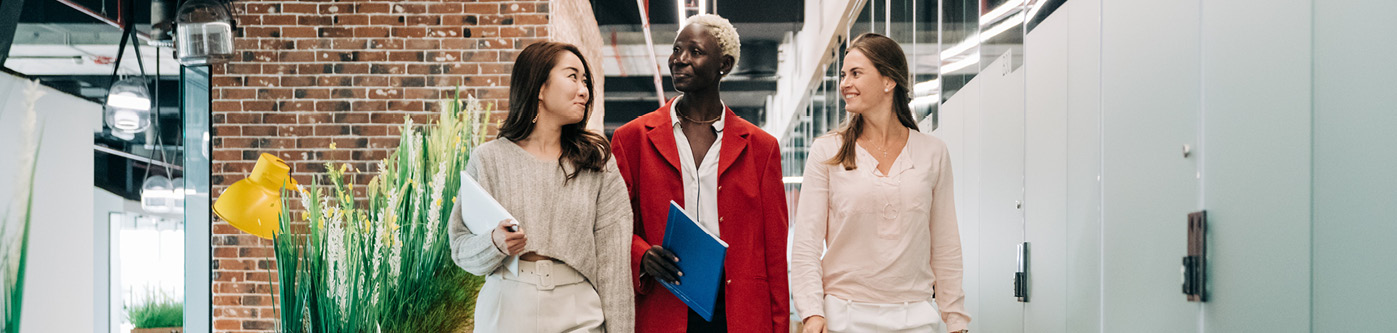 energy saving tips for employees - 3 female employeese walking through an office building