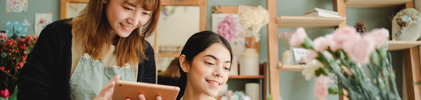 Business owner looking at reducing energy consumption on tablet in florist shop