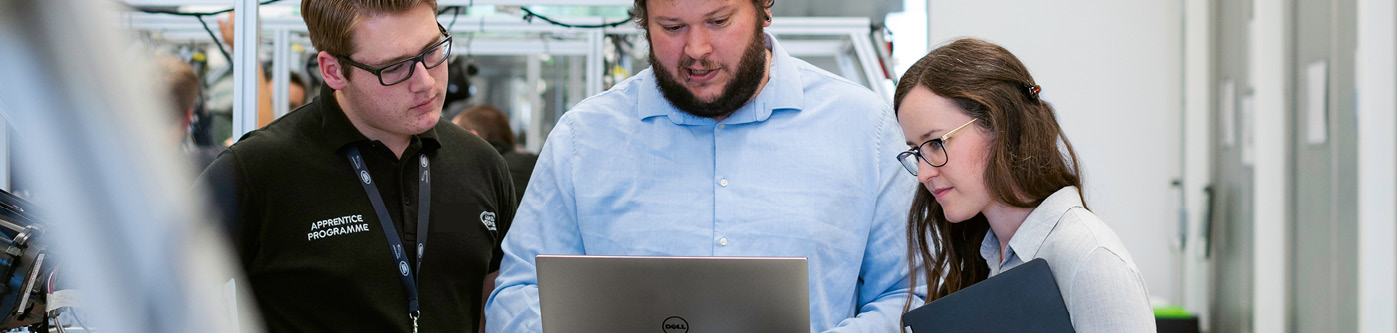 3 engineering employees looking at laptop