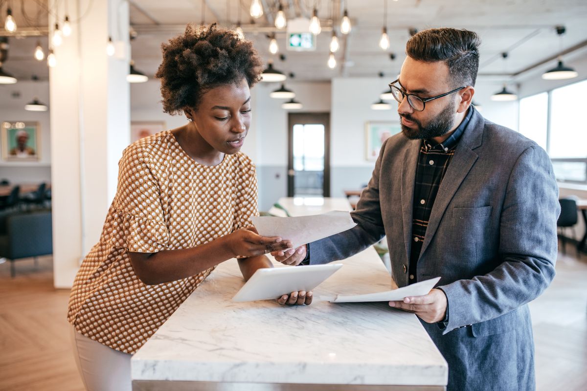 a female business owner discusses a dispute with a male energy broker. they are in a modern office environment