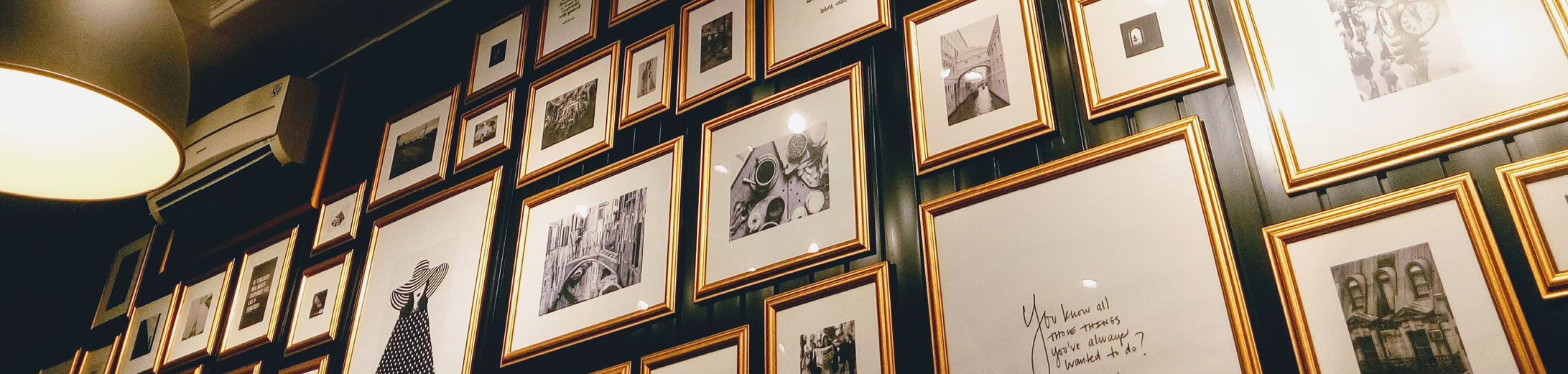 Image shows a number of black and white photographs and illustrations displayed on the wall of a restaurant or cafe. This goes alongside a story about creating new revenue streams for businesses, through selling local artist and crafters work.