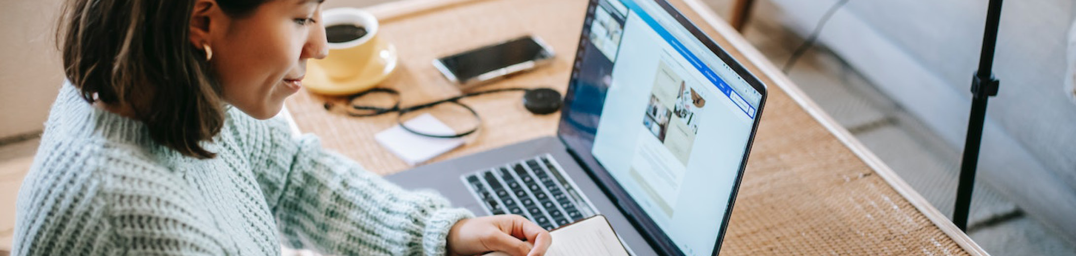 a business owner creating a content strategy for small business at laptop on wooden desk