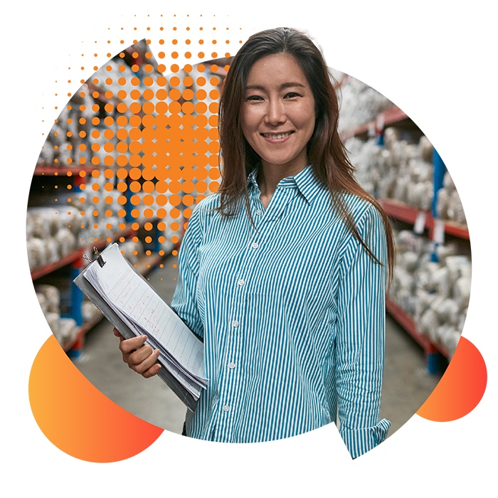 Commercial energy providers. A smiling, female large business owner stands amongst the shelves in her warehouse.