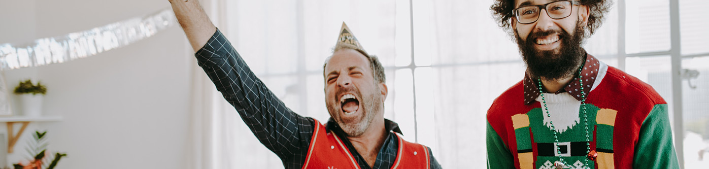 Preparing your employees for christmas - two employees in christmas jumpers celebrating in the office