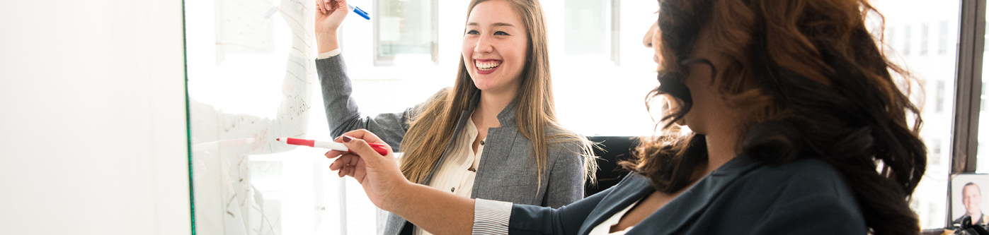 Two female office workers discussing the best energy saving tips for offices