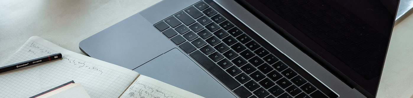 An image of a laptop with an open notebook. The notebook shows notes on how to create a newsletter thats engaging