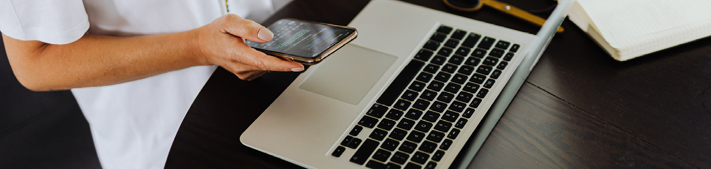 Someone using a mobile phone and laptop at the same time