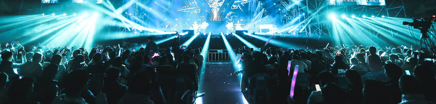 bright blue lights shining on a large concert. Music venue energy usage is high.