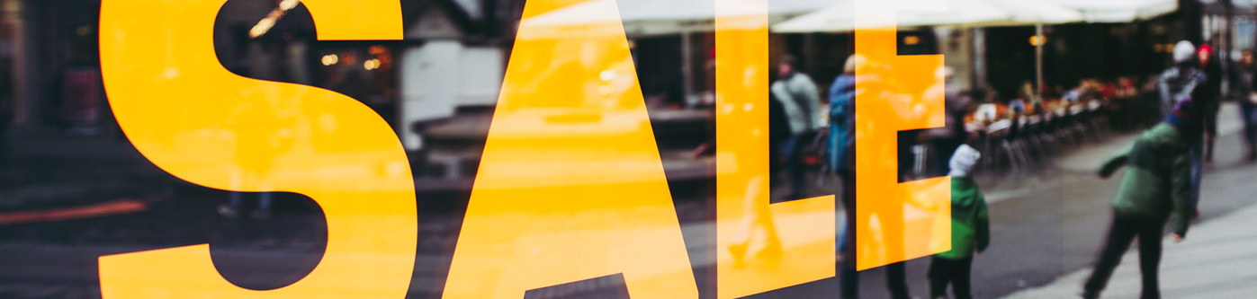 A window with a large sale sign in yellow across it