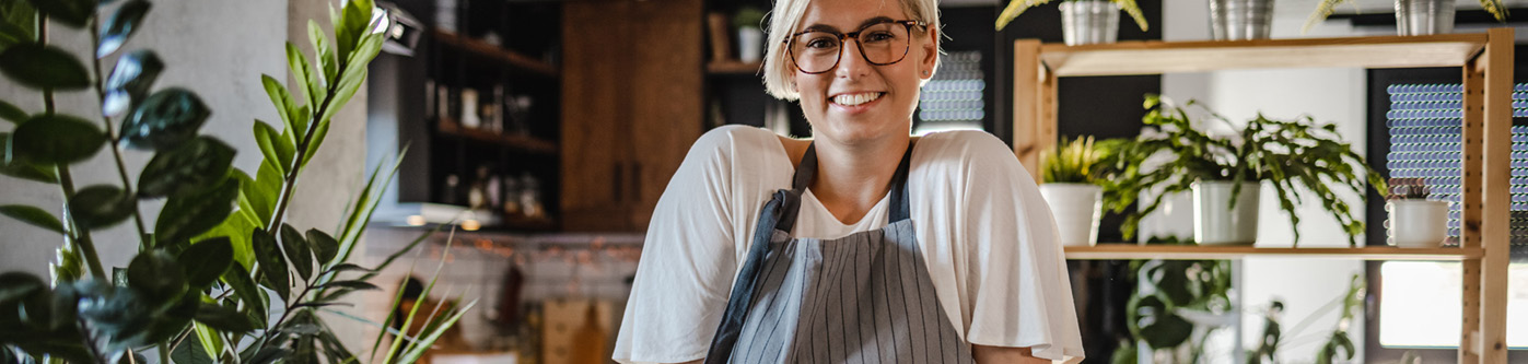 A happy, smiling business owner behind the counter in her sustainable business