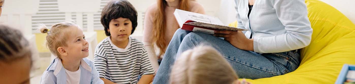 Energy saving tips for schools - a teacher reads a book to a primary school class