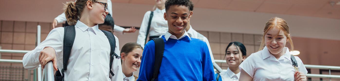 secondary school student in a hallway, dressed in uniform. How can schools save energy?