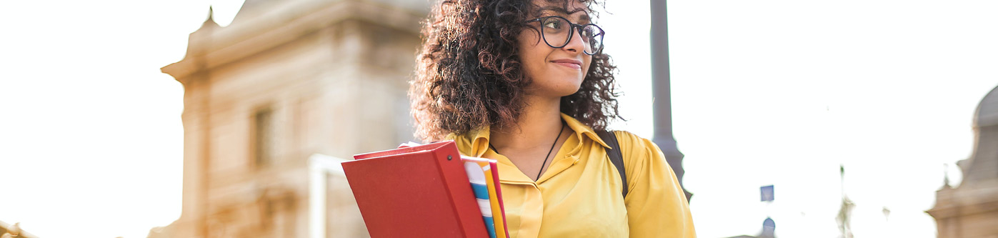 a female university student wearing a yellow top, with curly brown hair, is learning about energy efficiency