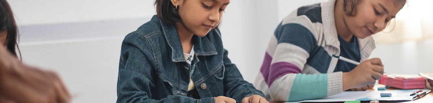 two school girls drawing at school, learning about energy