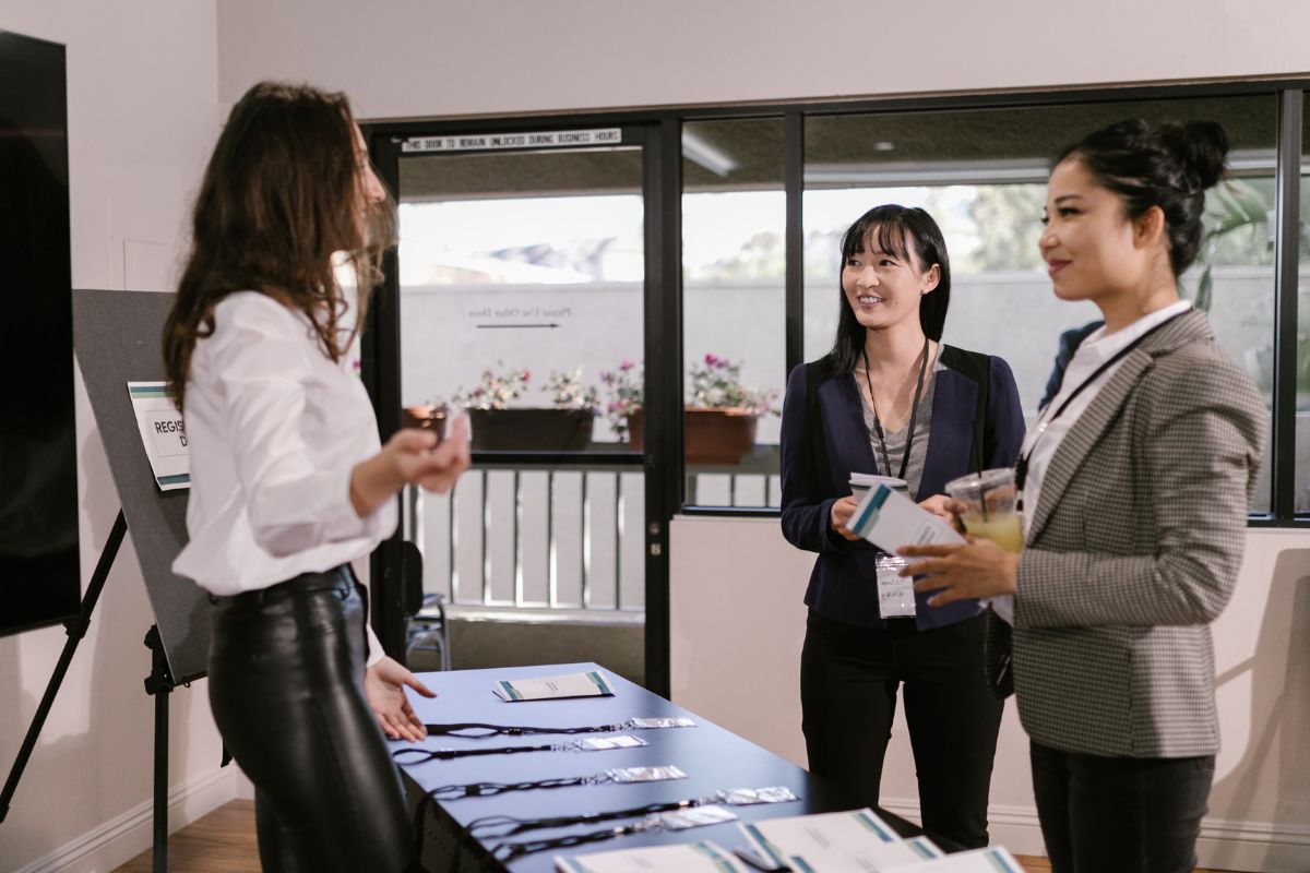 business owner discussing services with two delegates at an exhibition